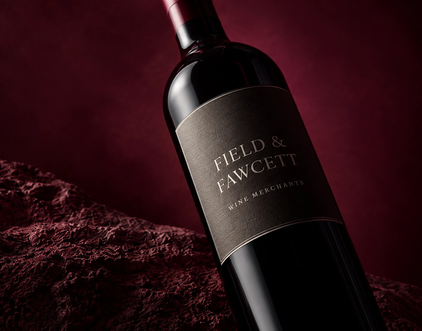 A wine bottle on burgundy stone, with a Field & Fawcett label